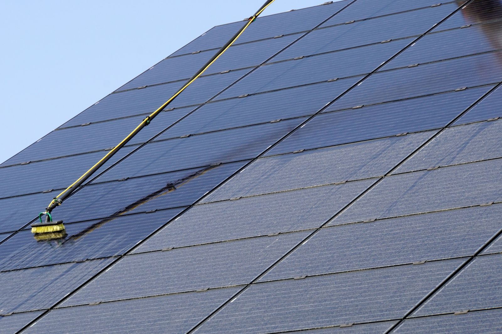 Großflächige Photovoltaikanlage auf einem Hallendach während der fachgerechten Solar-Modulreinigung